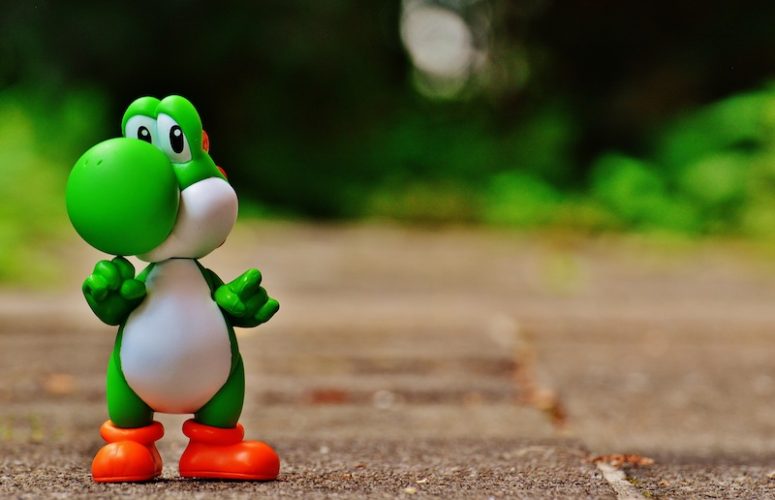 A Yoshi toy on a green background