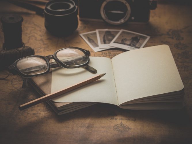 Eyeglasses on top of an empty notebook